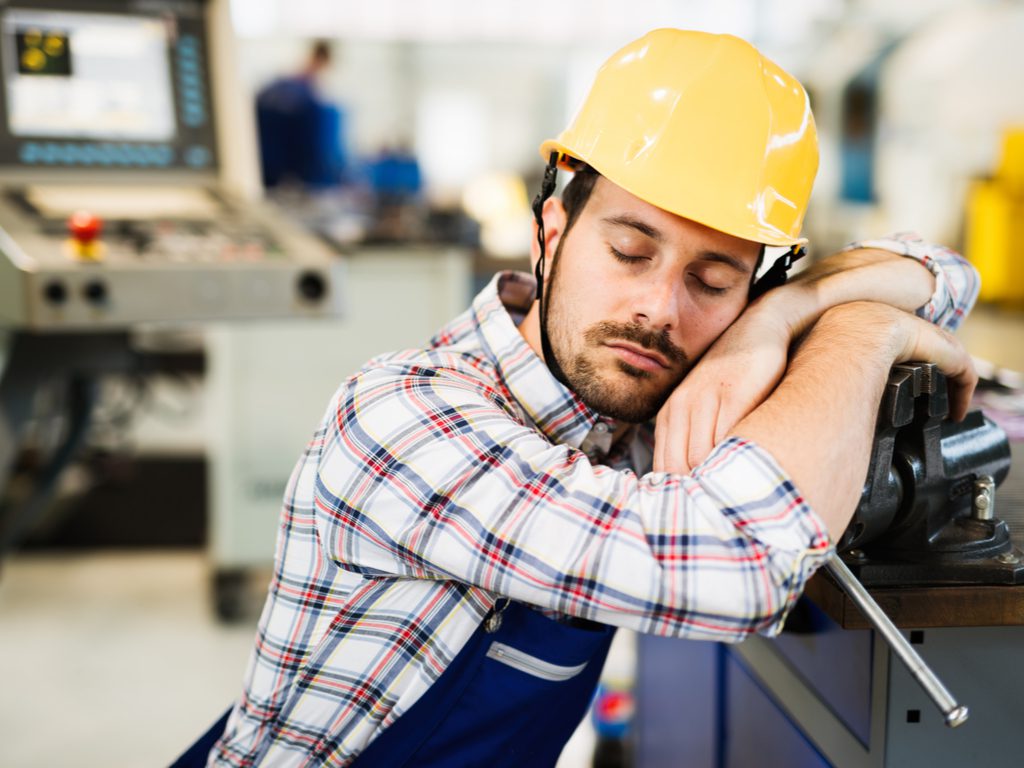 Man falling asleep at work due to untreated sleep apnea.