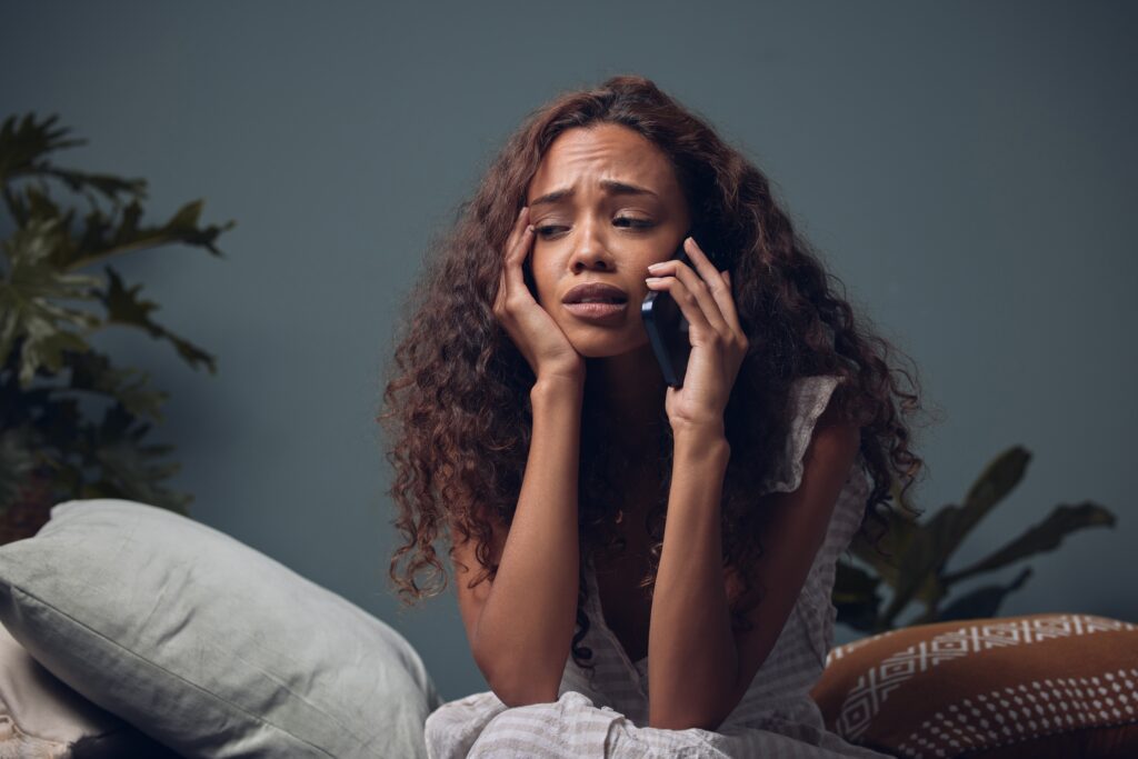 woman crying and stressed out on the phone, suffering from insomnia or sleep apnea
