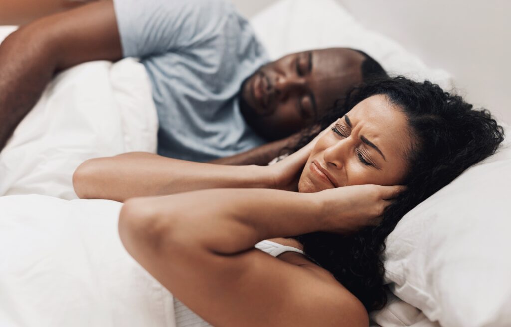 Angry, snoring and couple in bed with sleep apnea frustrated by husband with noise, problem and upset woman