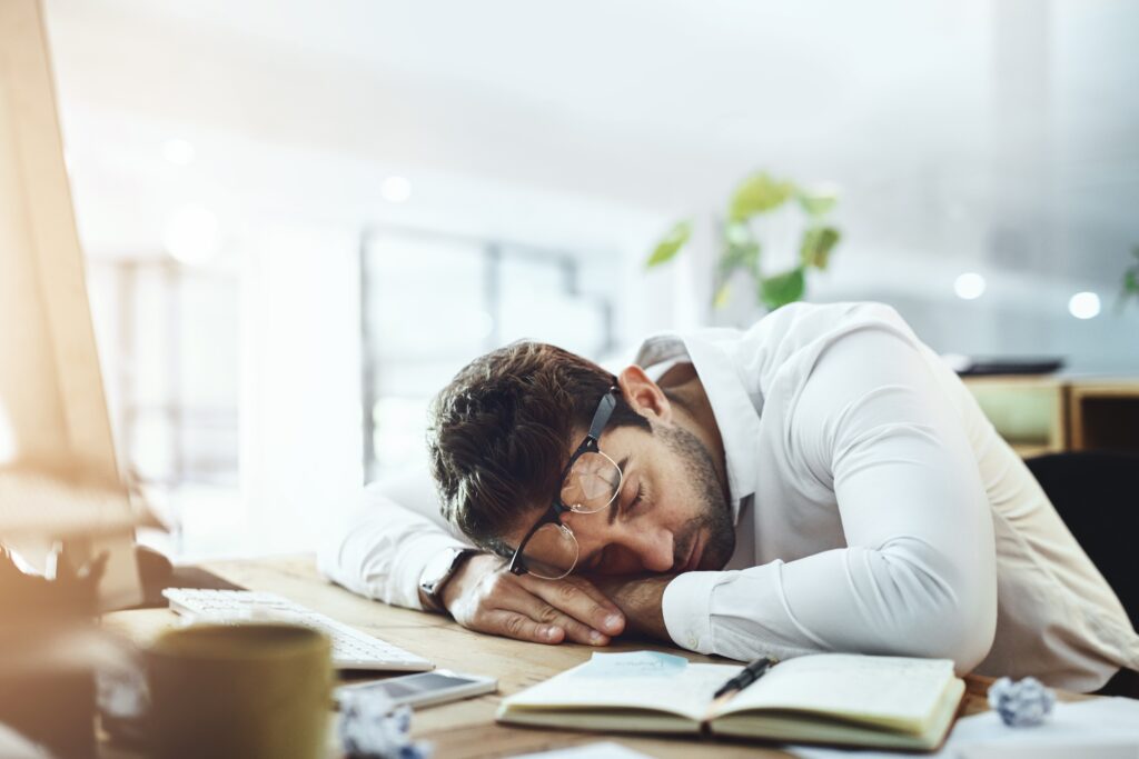 Tired, sleeping, and a businessman passed out at his desk